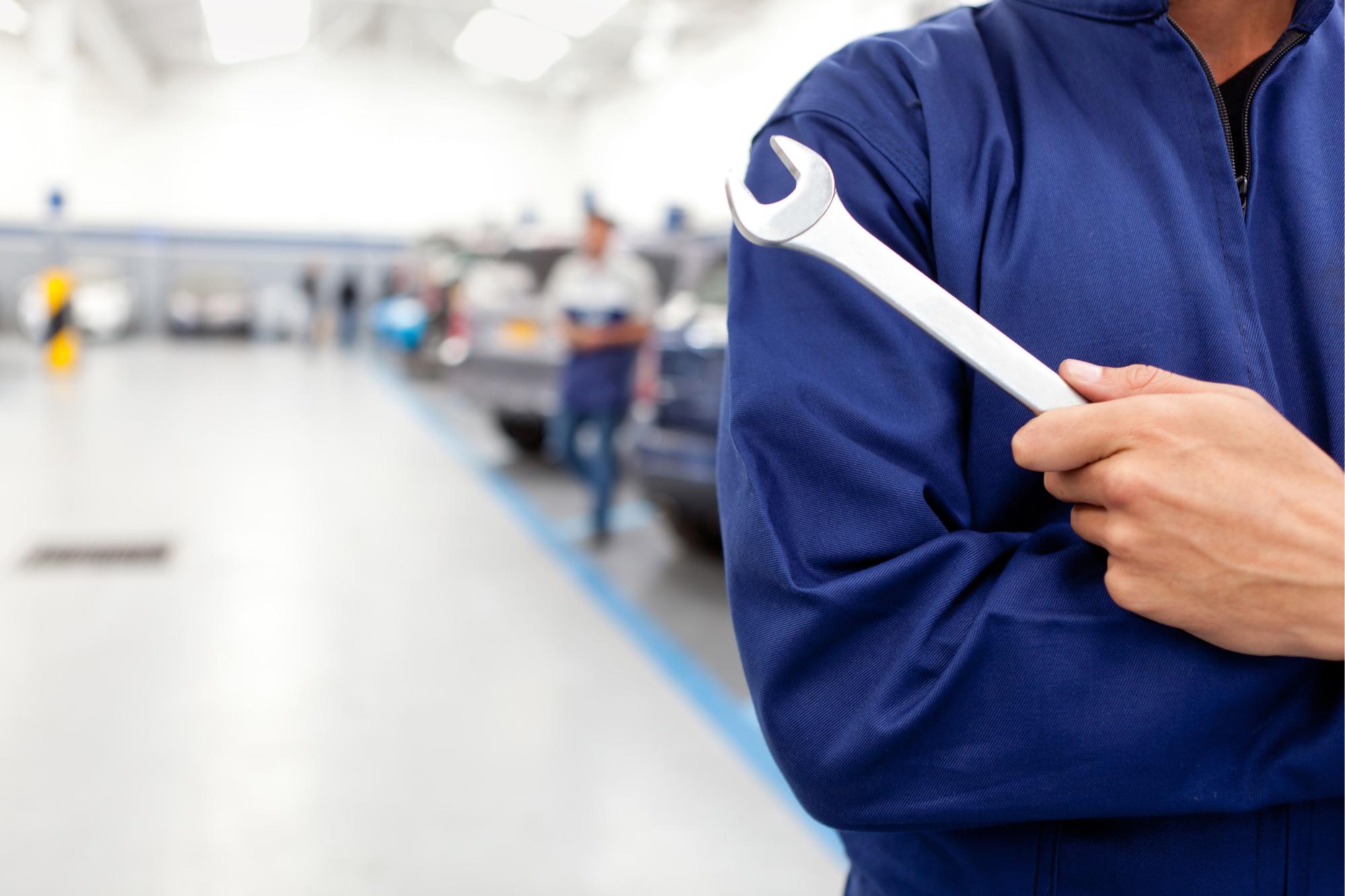 mechanic holding wrench in shop