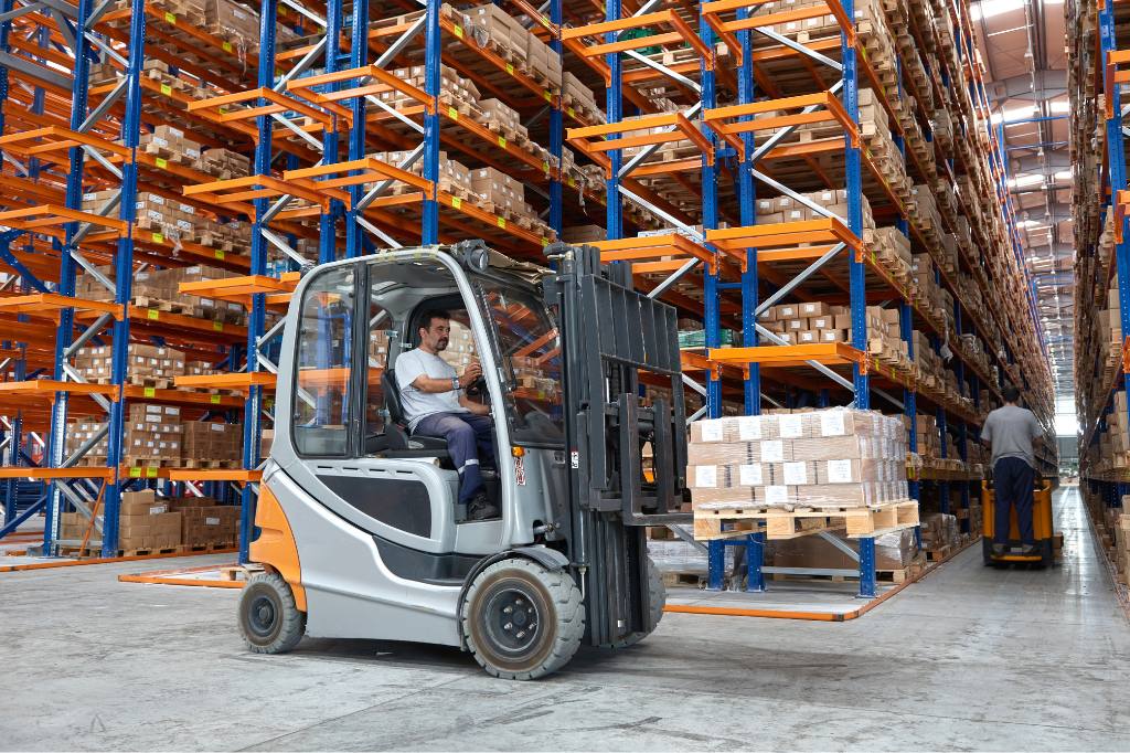 man driving forklift in warehouse