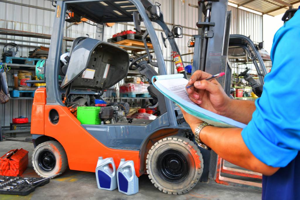 man with notebook in front of forklift