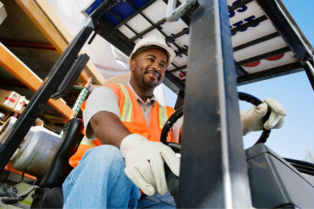 smiling man driving forklift