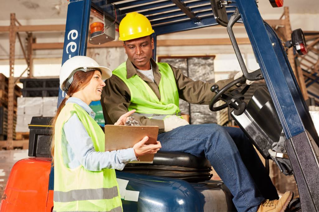 woman talking to man on forklift